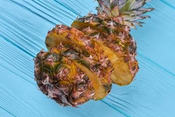 Ripe sliced pineapple on blue wooden background. Fresh juicy pineapple fruit on color wooden surface. Healthy exotic fruit.