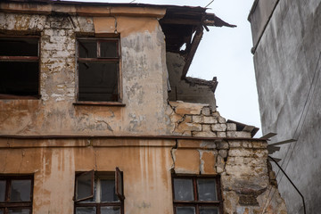 Fototapeta na wymiar Ruins of an old abandoned city. Ruined house in which poor people live. Odessa, the ruins of a historic residential building. The ruins of an old earthquake-hit house. Lost city.