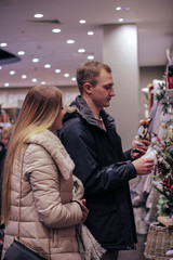 Beautiful couple with shopping bags is talking and smiling while doing shopping in the mall. young couple shopping before the holiday