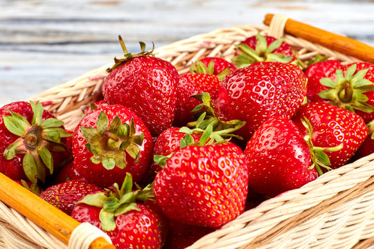 Close up ripe sweet strawberries in basket. Natural summer berries. Harvest of organic strawberries.