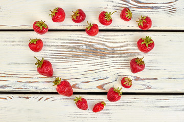 Heart shape from fresh ripe strawberries. Delicious summer berries forming heart shape on vintage wooden surface.