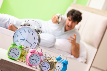 Young man having trouble waking up in early morning
