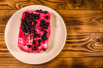 Ceramic plate with cheesecake on wooden table. Top view