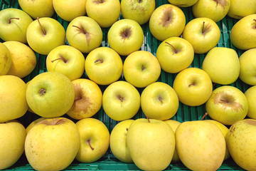Pile of yellow apples in supermarket