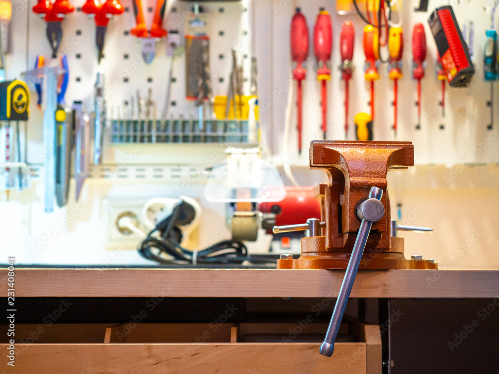 Poster workshop. the vice is fixed on the table. workplace with tools. tool for a hobby. workbench with a v