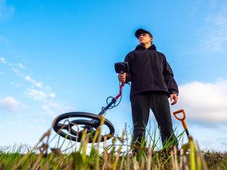 Metal search. A man holds a metal detector in his hand. Search for treasures. Search for antique...