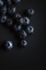 Several blueberries on black background