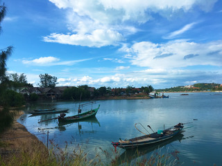 Fototapeta na wymiar Three boats on the water, tropical village