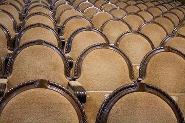 brown rows of arm-chairs of visual hall of theatre.
