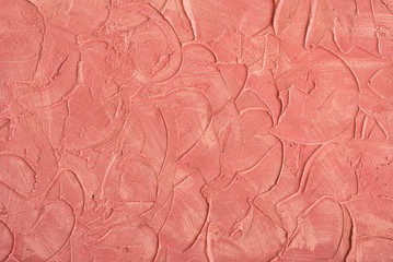 Relief stucco on the wall. Red color. Close up