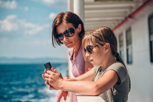 Mother and daughter traveling on ferry and taking pictures