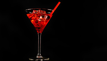 Red refreshing cocktail prepared by the bartender on a black background