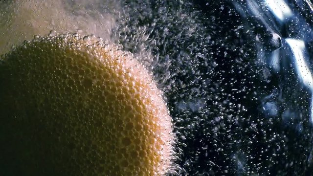 Effervescent tablet falling in water glass slowmotion