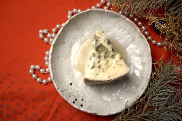 a piece of cheese with mold on a festive New Year's table selective focus.