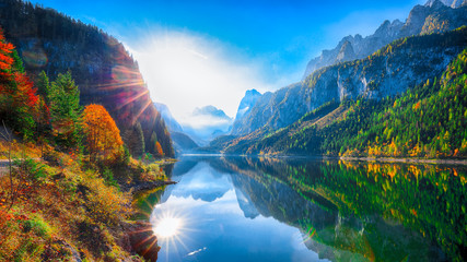 Fototapeta na wymiar autumn scenery with Dachstein mountain summit reflecting in crystal clear Gosausee mountain lake