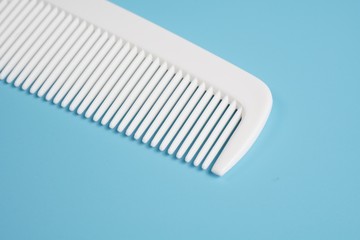 White hair comb isolated on blue background