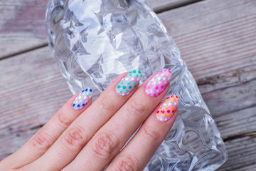 nail art manicure with colorful polish nails and bottle of water. Beauty hand and stylish nails.