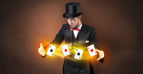 Illusionist in tails bandy play cards between his two hands