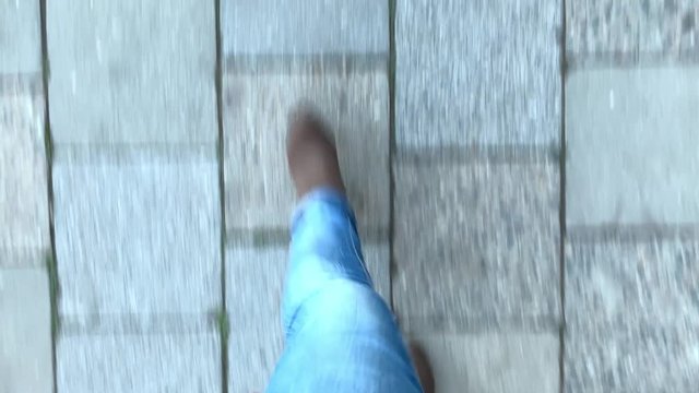 Top view feet walking on the street. Legs of a female as walking on pavement. First person POV. 