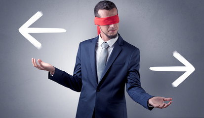Covered eye businessman choosing between two directions 