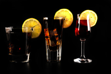 mixed drinks in shot glasses prepared by the bartender on a black background