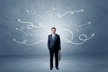 Elegant businessman choosing between directions with winding drawn arrows around 
