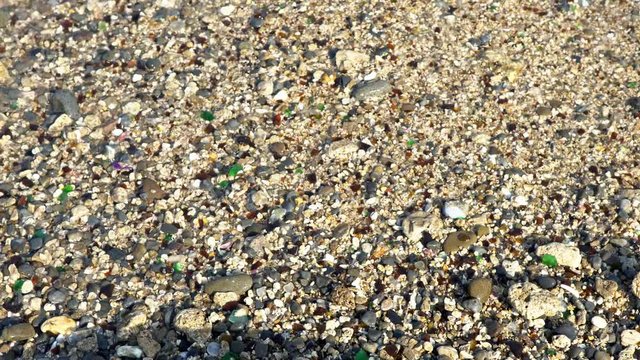 4K ocean beach of peebles with the foam of the waves in motion at Taiwan Island. Sea surfs are splashing on multi colored polished stones. The wave on the shore-Dan