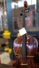 Ancient double bass, cello tied with a rope.