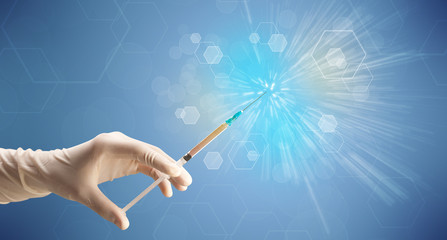 Female doctor hand holding syringe with shiny background