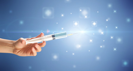 Female doctor hand holding syringe with shiny crosses in the background