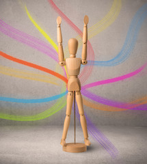 Wooden mannequin posed in front of a greyish background with colorful lines behind it