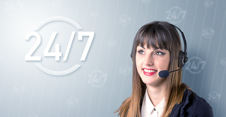 Young female telemarketer with a 24 7 sign next to her