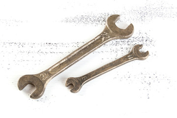 Vintage bronze wrenches on shabby background