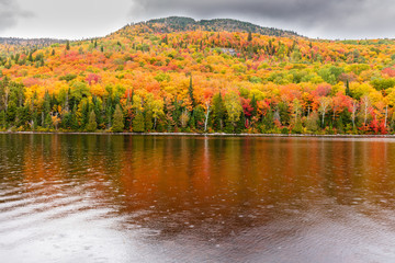 Fall colors of Lac Legault with Mont Kaaikop in the background, in cottage country in the Laurentians, Quebec, Canada.