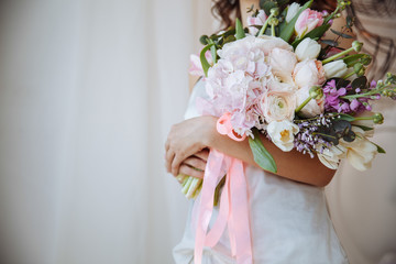 Beautiful wedding bouquet in the hands of a beautiful bride