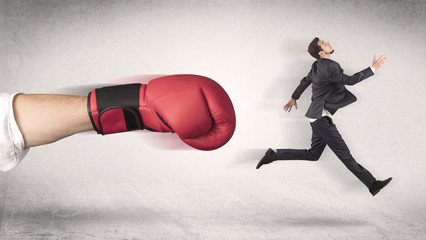 Businessman gets fired from his job by a huge hand in boxing gloves