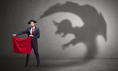 Fototapeta premium Businessman standing with red cloth in his hand and imp shadow on the background 
