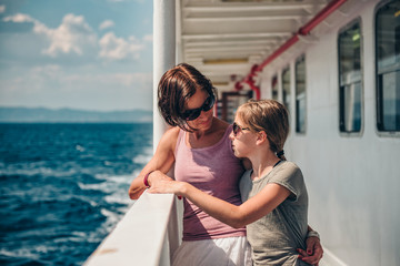 Mother and daughter standing on a ship deck and talking