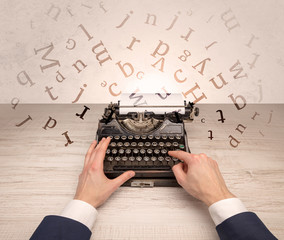 First person perspective elegant hand writing on typewriter with flying letters concept
