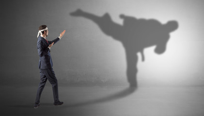 Fototapeta premium Businessman fighting with his strong karate man shadow 