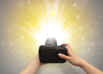 Naked hand taking picture with digital camera and glowing flash concept

