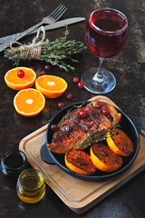 Chicken breast baked with tangerines and spices. A glass of red wine. Festive dinner for one. Christmas dinner.