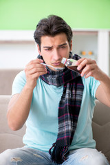 Young handsome man suffering from illness at home 