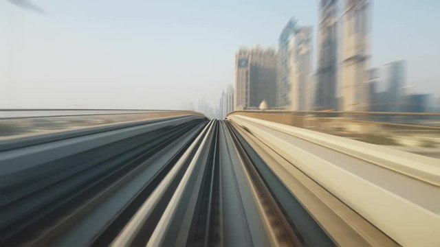 Time lapse view of Dubai metro from a moving fast train. The rails and platform shimmer in an extremely quick way on a sunny day in summer. Timelapse