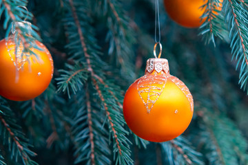 Orange balls on spruce, part of the Christmas tree with Christmas decorations