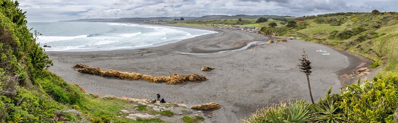 La Rinconada Beach close to Cobquecura town is a wild beach with a wonderful scenery. Big waves approaches the coast and impact to the sand dunes on the beach where the fishermen boats wait. Chile
