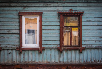 Modern plastic window next to the old wooden frame