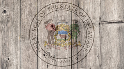 USA Politics News Concept: US State Delaware Seal Wooden Fence Background