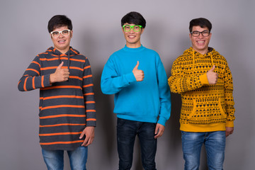 Three young Asian friends together against gray background