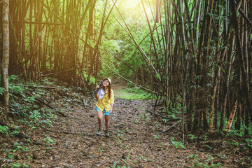 Naklejka na ściany i meble Photographer woman fun happy with walking travel nature. Travel relax and nature Study. In the bamboo forest in the summer.